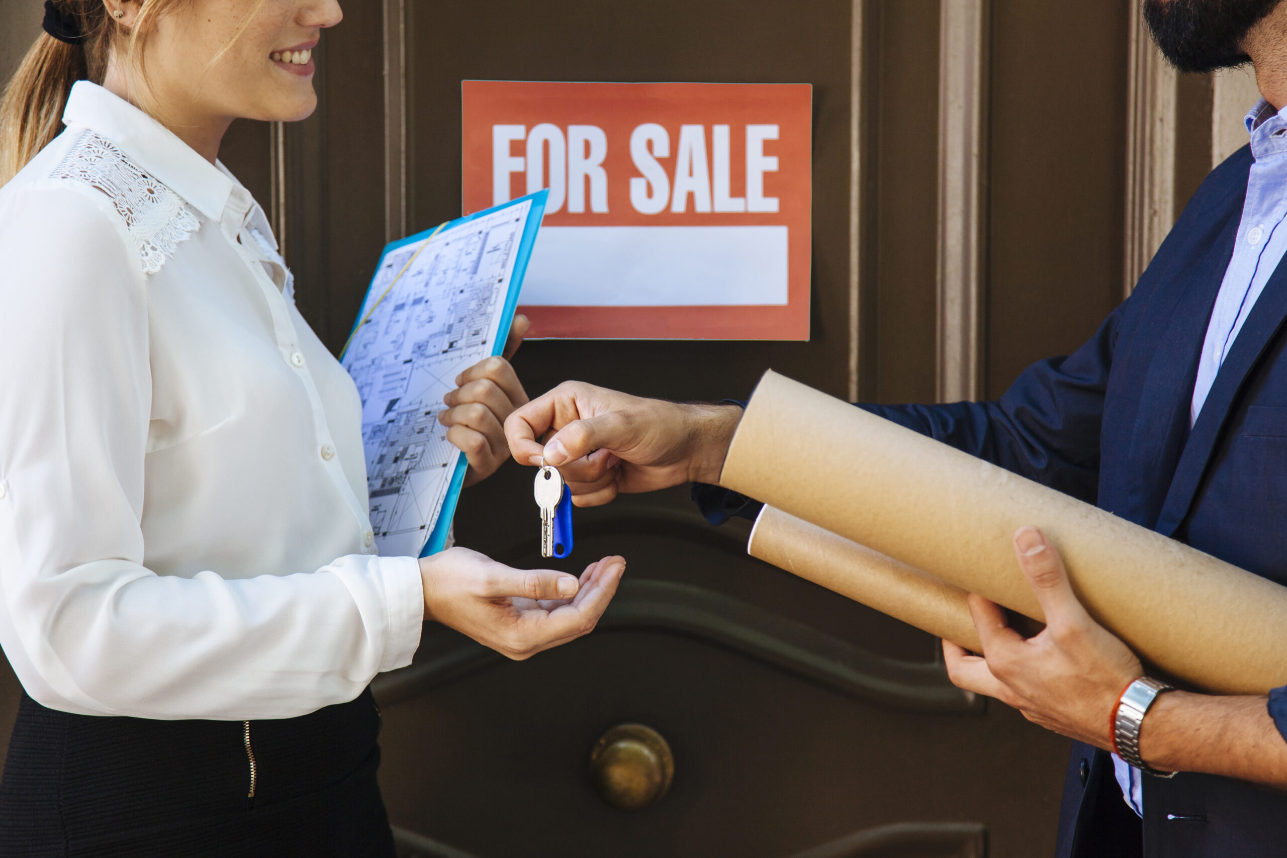 woman receiving key from real estate agent